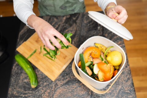 Women cooking uses compost bin